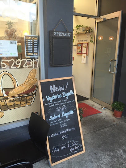 Storefront sign and specials board outside Authentic Bakery & Cafe